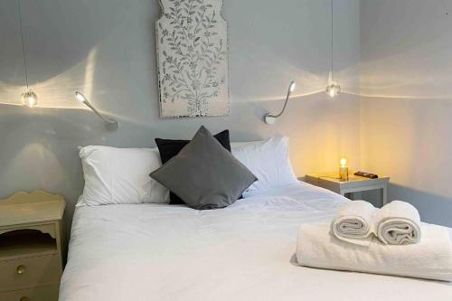 a bedroom with a white bed with towels on it at Charming 2-Bed Apt with 2 bathtub central London in London