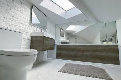 a white bathroom with a toilet and a sink at Charming 2-Bed Apt with 2 bathtub central London in London