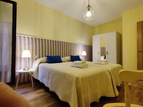 1 dormitorio con 1 cama grande con almohadas azules en Alojamiento Real Monforte de Lemos, en Monforte de Lemos