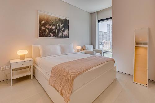 a white bedroom with a large bed and a window at Magnificent apartment in Address Beach Residence, 1 BR, the 6th floor in Dubai