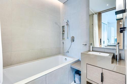 a white bathroom with a tub and a sink at Magnificent apartment in Address Beach Residence, 1 BR, the 6th floor in Dubai