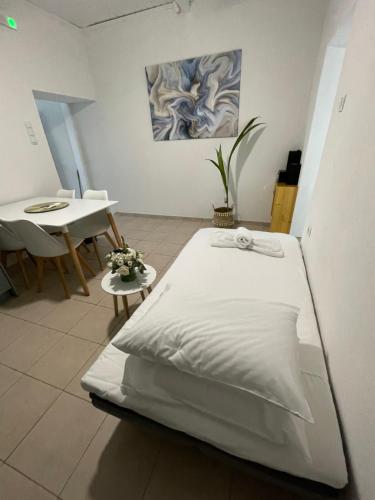 a white bed in a room with a table and a tableablish at Aqua Vero Seaside Residence in Hersonissos