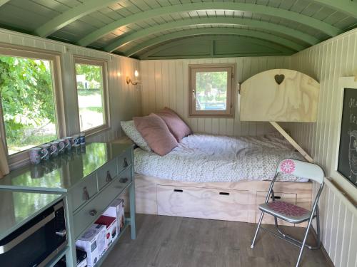 um quarto com uma cama numa pequena casa em Tiny house, pipowagen onder de kastanje em Aalten