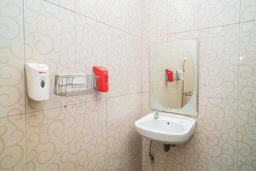 a bathroom with a sink and a mirror at RedDoorz At Jalan Bukit Keminting in Palangkaraya