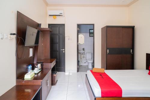 a hotel room with a bed and a bathroom at RedDoorz @ Wisma Pangrango in Palangkaraya