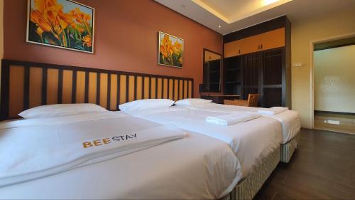 two beds in a hotel room with white sheets at Gold Coast Morib Studio l Apartment I Penthouse in Banting