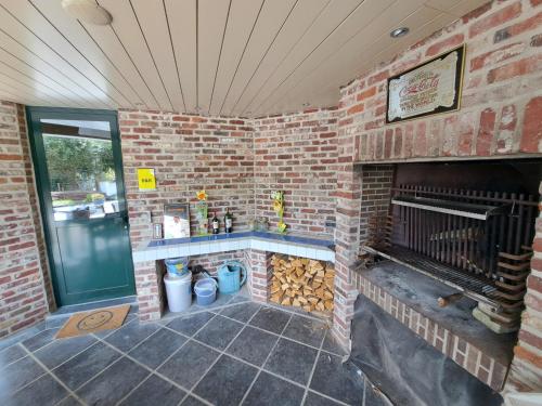 a brick room with a brick fireplace with logs at Rêveries in Roeselare