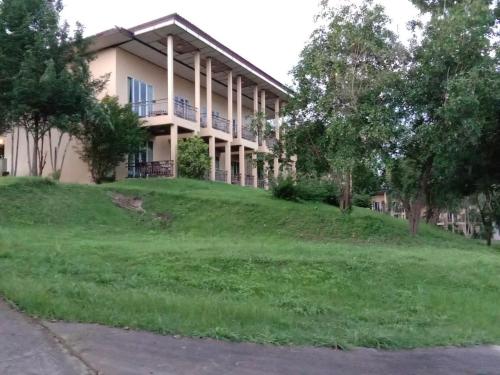 a large building on a grassy hill with trees at Nakakiri Resort & Spa in Hin Dat