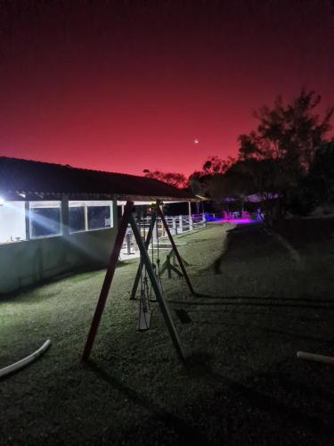 a picnic table in front of a building at night at Pousada Sitio Roda D'Água Mairinque in Mairinque