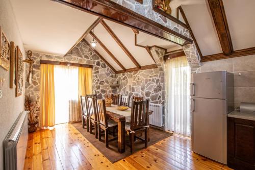 a kitchen with a table and chairs and a refrigerator at Family SPA Apartments Sunny&Shiny in Šavnik