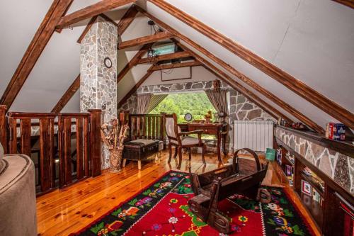 ein Wohnzimmer mit Dachschrägen und ein Esszimmer in der Unterkunft Family SPA Apartments Sunny&Shiny in Šavnik