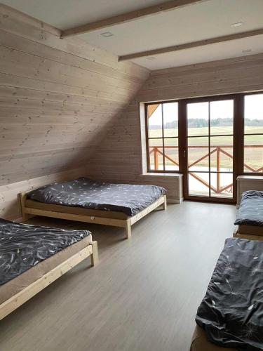 a room with three bunk beds and a large window at Bareišių sodyba in Moškėnai