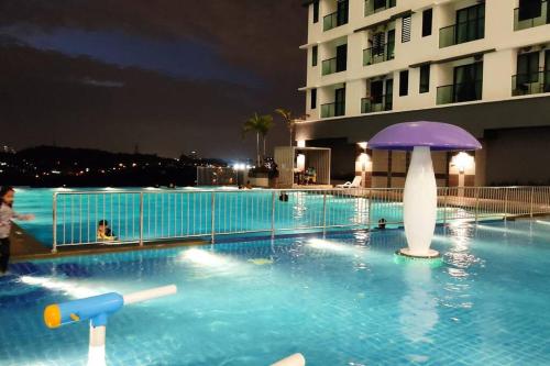 una piscina con una sombrilla púrpura frente a un edificio en Hidayah Homestay near UKM and KTM station with high speed wifi - pool & river view en Bangi
