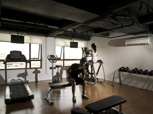 a man and a woman exercising in a gym at Grand Zuri Kuta Bali in Kuta