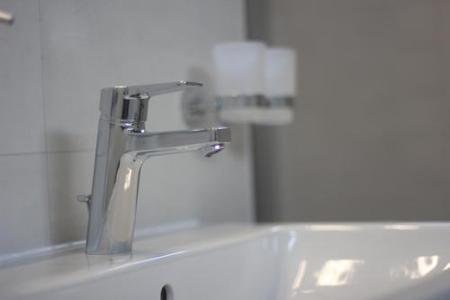 a bathroom sink with a faucet and a mirror at BNB Klinga in Klinga