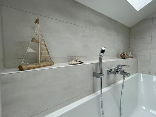 a bathroom with a bath tub with a boat on a shelf at BNB Klinga in Klinga