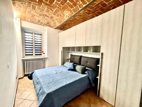 a bedroom with a bed and a brick wall at Cá d la trifola free parking in Alba