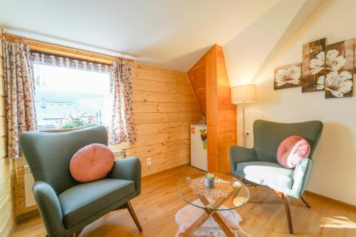 a living room with two chairs and a glass table at Penzion Sagan in Terchová