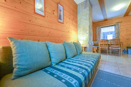 a couch in a room with a wooden wall at Penzion Sagan in Terchová
