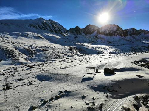 a snow covered mountain with the sun in the sky at Prime Loft ANDORRA HUT2-06207 in Pas de la Casa