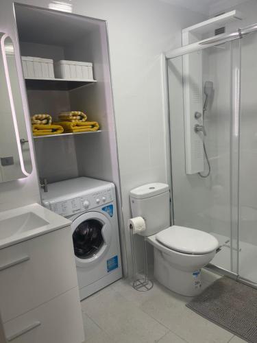 a bathroom with a toilet and a washing machine at Monsenor in Playa del Cura