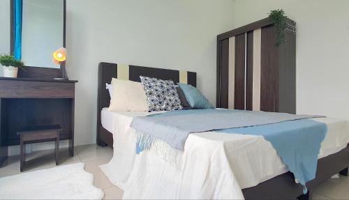 a bedroom with a large bed with a wooden headboard at Ipoh Meru Casa Kayangan by BeeStay in Ipoh