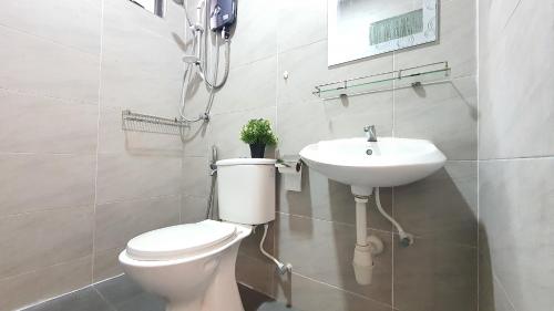 La salle de bains est pourvue de toilettes et d'un lavabo. dans l'établissement Ipoh Meru Casa Kayangan by BeeStay, à Ipoh