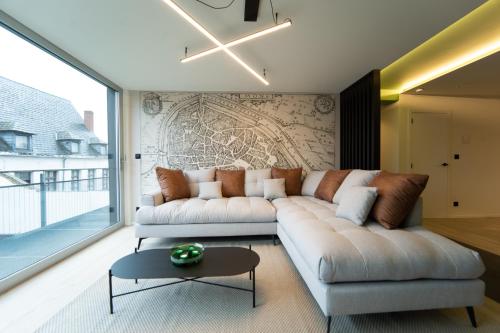 ein Wohnzimmer mit einem Sofa und einem Tisch in der Unterkunft Green Appart - A&B Best Quality - Mons City Center in Mons