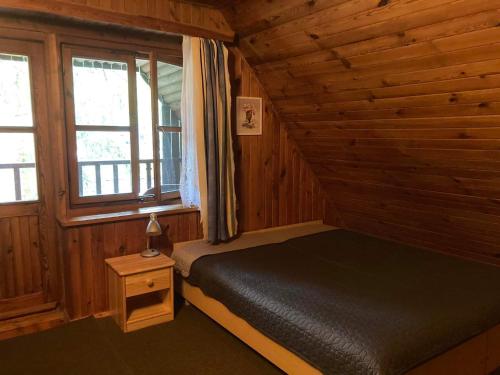 a bedroom with a bed in a wooden cabin at Dom pod Sosnami in Narty