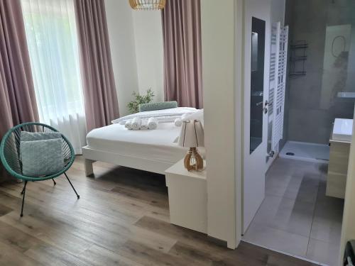 um quarto com uma cama, uma cadeira e uma banheira em AZUR ROOMS LJUBLJANA em Ljubljana