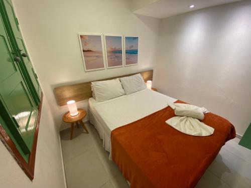 a small bedroom with a bed and two towels at Chalés Praias do Sul in Porto De Galinhas