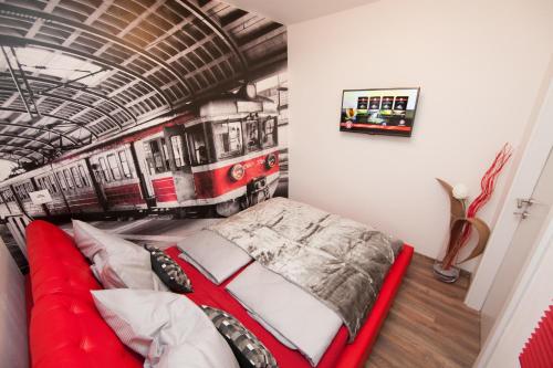 ein Schlafzimmer mit einem roten Bett in einem Bahnhof in der Unterkunft Deluxe Apartment Vienna in Wien