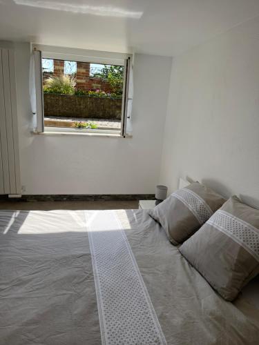 a bed in a room with a window at L'appart du RIED in Heidolsheim