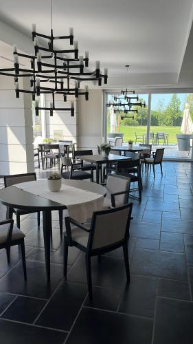 a dining room with tables and chairs under a chandelier at Casabianca Resort in Fondi