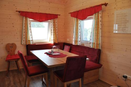 comedor con mesa de madera y sillas rojas en Ferienhaus Altmann 2, en Sankt Magdalena