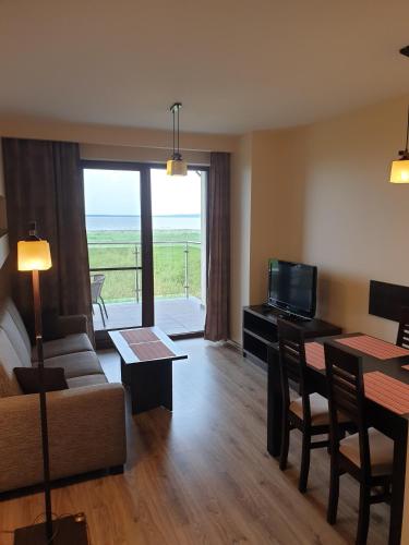 a living room with a couch and a table with a television at Apartamenty z widokiem na Zalew in Krynica Morska