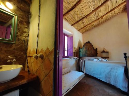 La salle de bains est pourvue d'un lavabo et d'un lit dans la chambre. dans l'établissement holiday home su Niberalzu, à Monti