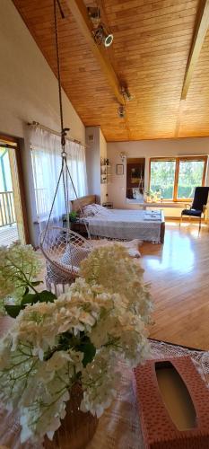 pokój z huśtawką, łóżkiem i kwiatami w obiekcie Spacious house with indoor pool & sauna. w mieście Ādaži