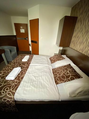 a large bed in a hotel room with two towels on it at Penzión DOMES in Čadca