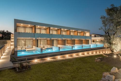 a building with a pool with lights in front of it at Lazaros Hotel Resort in Tsilivi