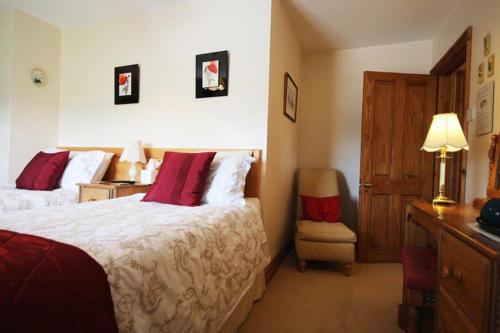 a hotel room with a bed and a chair at Fernydale Farm Bed & Breakfast in Earl Sterndale