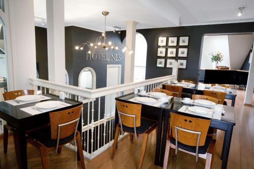 een eetkamer met een zwarte tafel en stoelen bij Hotel Nes in Amsterdam