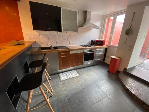 uma cozinha com um balcão e algumas cadeiras em La Maison d’Alie (Alie’s Home) em Boulogne-sur-Mer