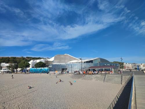 una playa con gente en la arena y un edificio en La Maison d’Alie (Alie’s Home), en Boulogne-sur-Mer