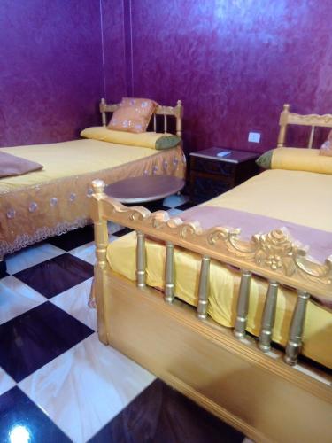 a room with three beds and a checkered floor at App11- BELAL - Enjoy the privacy of staying in a quiet apartment with free Wi-Fi as your complete second home in the heart of Hurghada in Hurghada