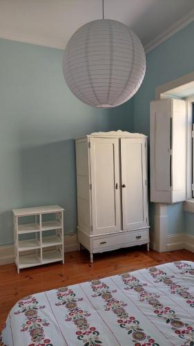 a room with a white cabinet and a chandelier at Casa da Carqueja 1 in Coimbra