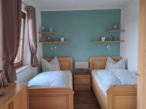 two twin beds in a room with two windows at FeWo "Waldblick" mit Pool und Kinderspielplatz in Dippoldiswalde