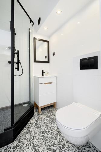 een badkamer met een wit toilet en een wastafel bij APARTAMENT SŁONECZNY in Chełmno