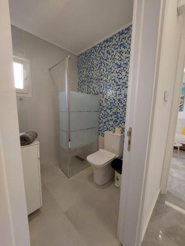 a bathroom with a toilet and a blue tiled wall at Amazing Napa Apartment in Ayia Napa