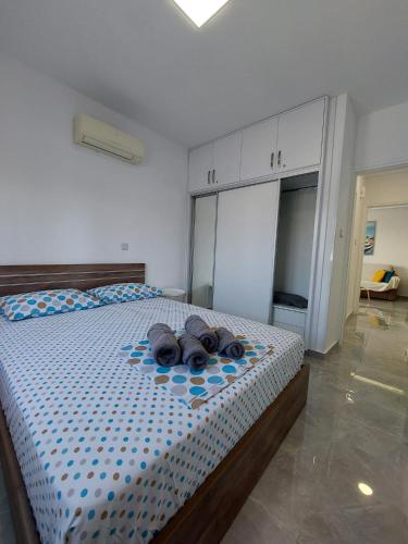a bedroom with a bed with two hats on it at Amazing Napa Apartment in Ayia Napa
